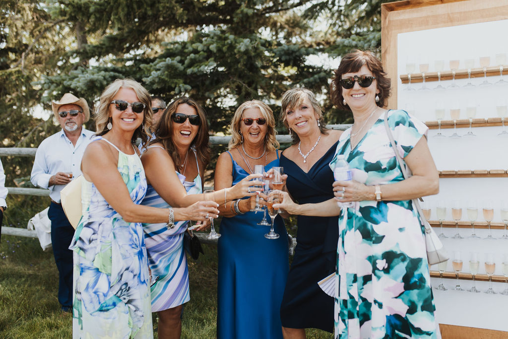 A group of women holding wine glasses at an outdoor event.