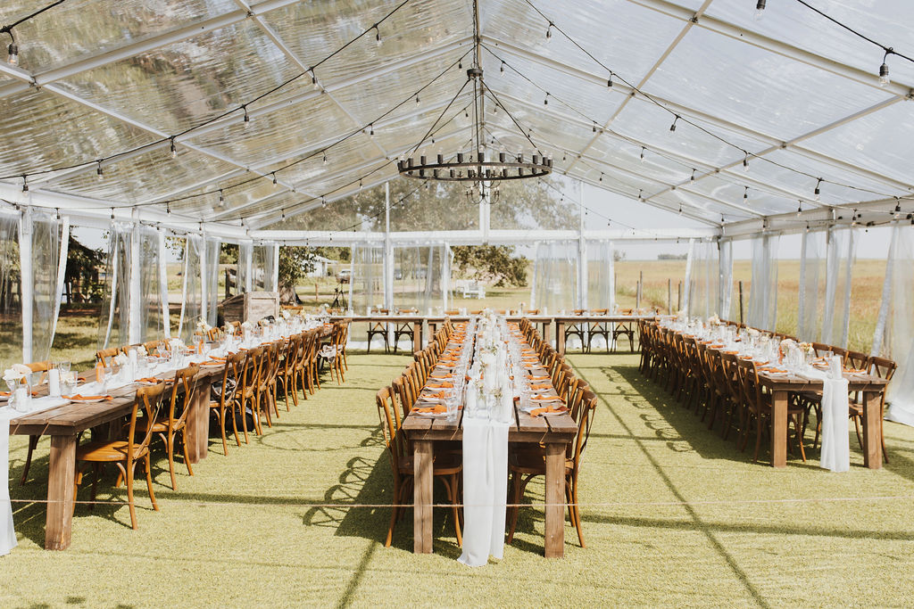 A clear tent set up for a wedding reception.