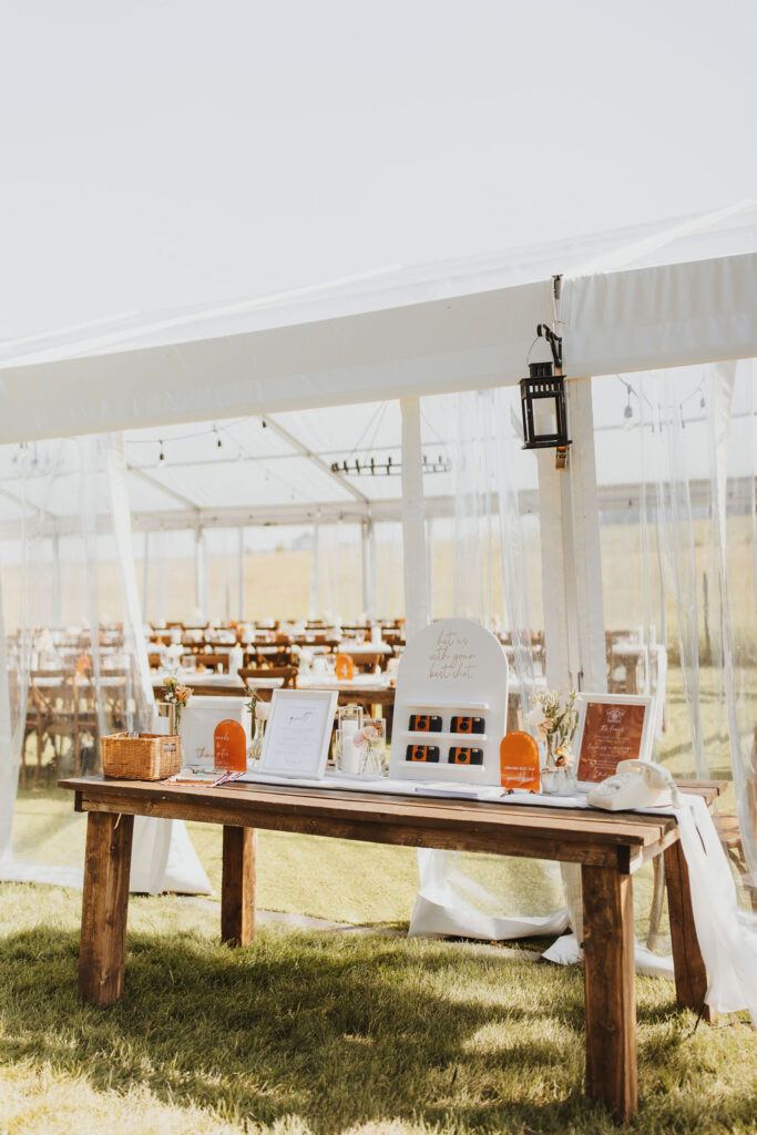 A white tent with a table and chairs in front of it. Outdoor Dinner Party