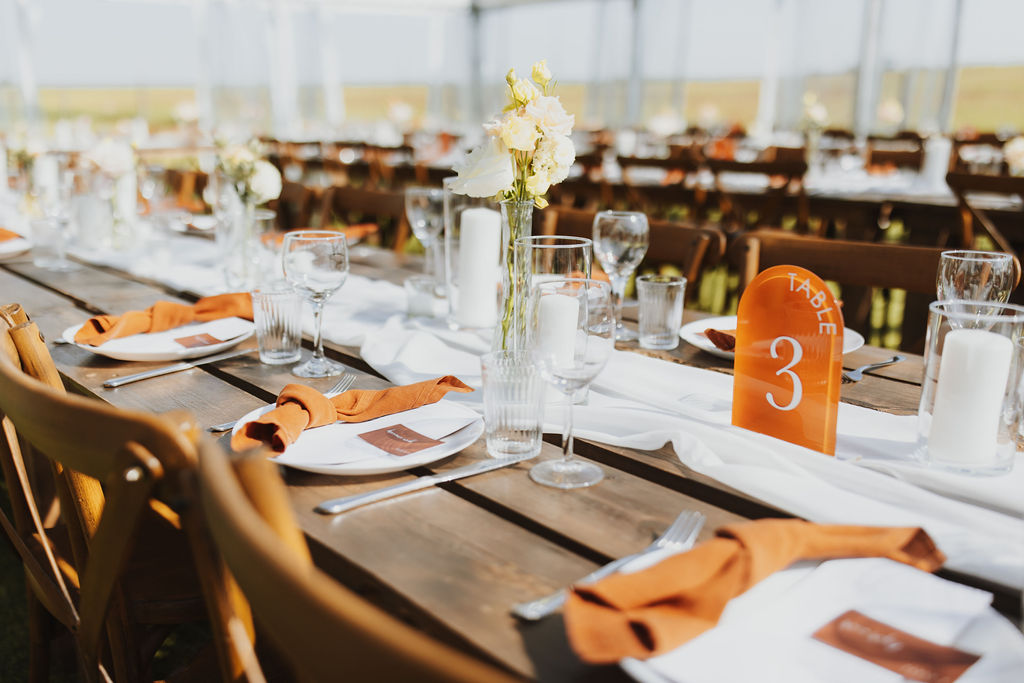 A table set up for a wedding in a tent. Outdoor Dinner Party.
