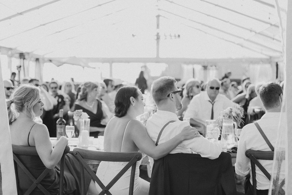 A black and white photo of a wedding reception in a tent.