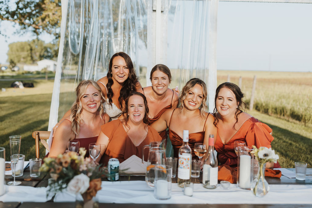 A group of bridesmaids posing for a photo at an outdoor wedding.