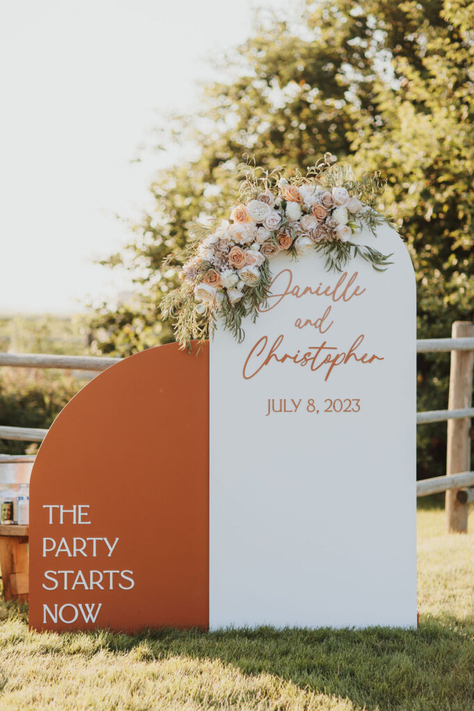 A wedding sign in front of a grassy field.