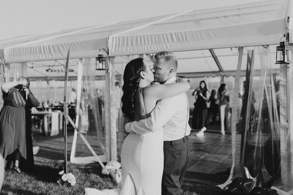A bride and groom share their first dance in front of a tent.