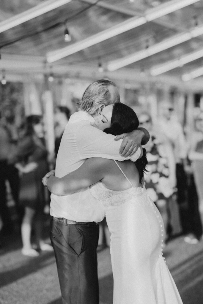 A bride and groom hugging during their first dance.