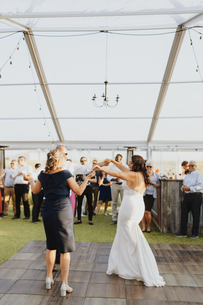 A bride and groom dancing on the dance floor at an outdoor wedding.
