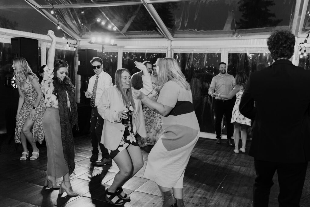 A black and white photo of people dancing at a wedding.
