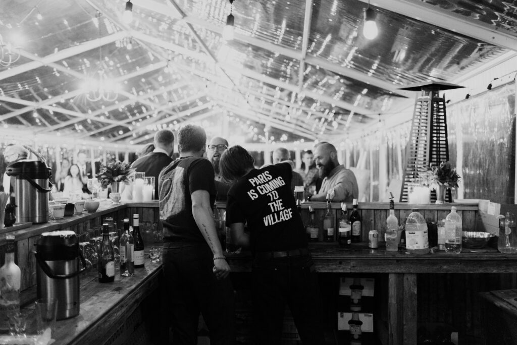 A group of people standing at a bar.
