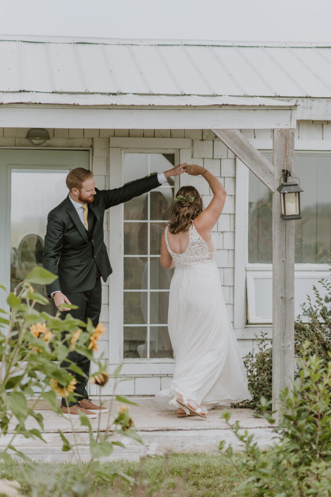 A bride and groom dancing at their first look on the porch of the bridal cottage at the Gathered in Calgary, Alberta. 