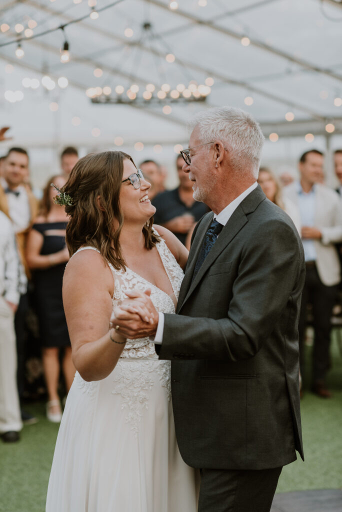 A bride and her father dance at their wedding reception.