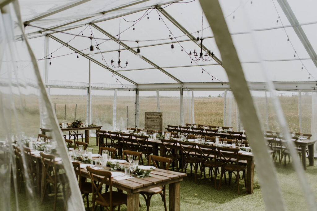 A wedding reception set up in a large tent.