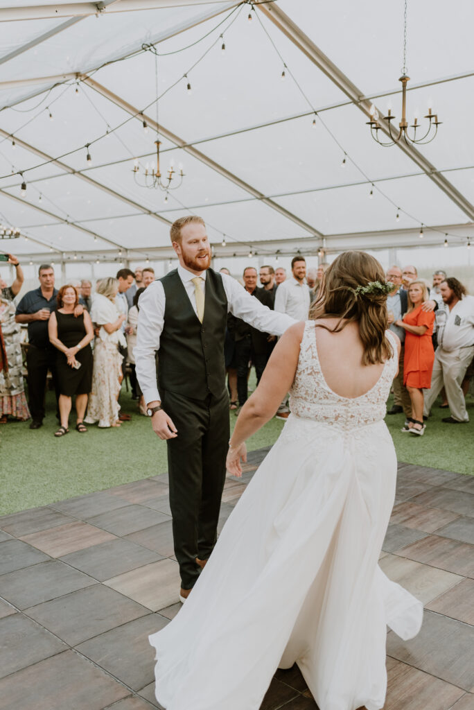 A bride and groom dancing in a tent.