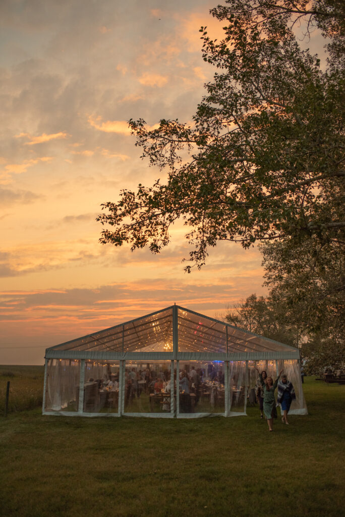 A large tent in a field at sunset.