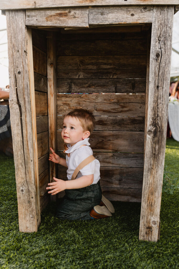 A little boy playing in a wooden box.