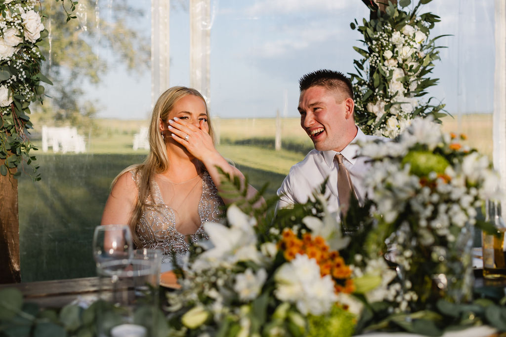 A bride and groom laughing at their wedding reception. diy florals
