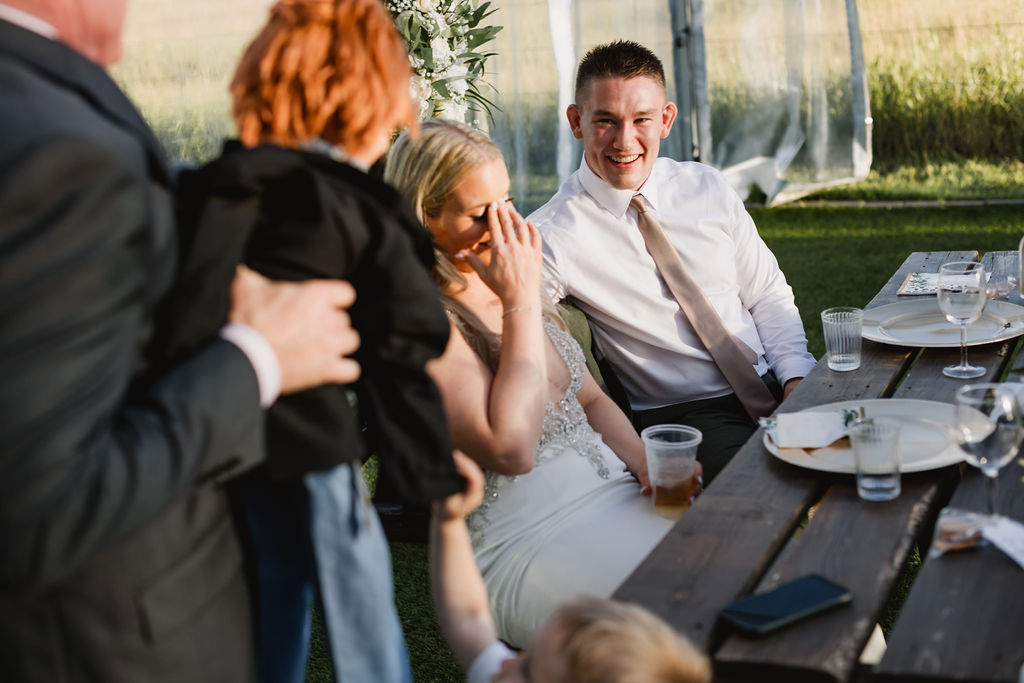 A group of people sitting at a table at a wedding.