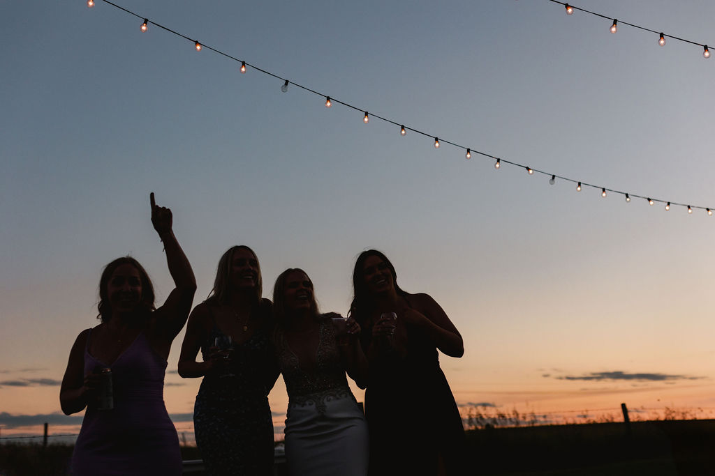 A group of bridesmaids posing for a photo at sunset.