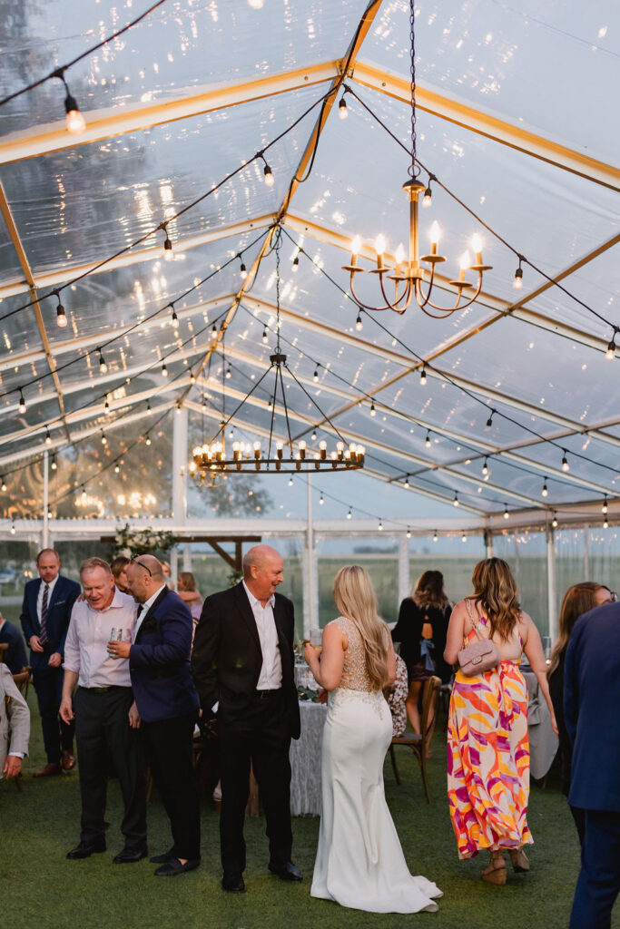 A wedding reception in a clear tent.