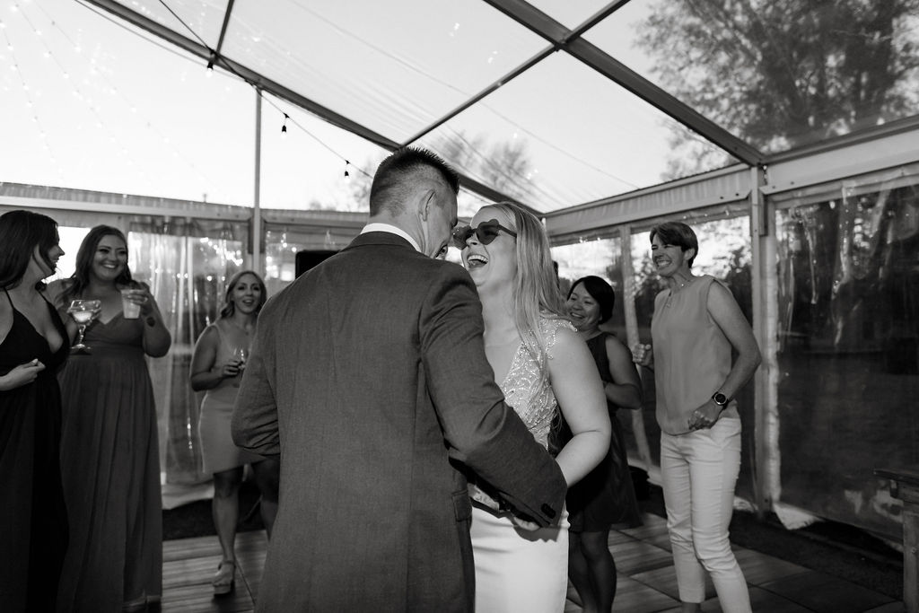 A bride and groom sharing a dance in a tent.