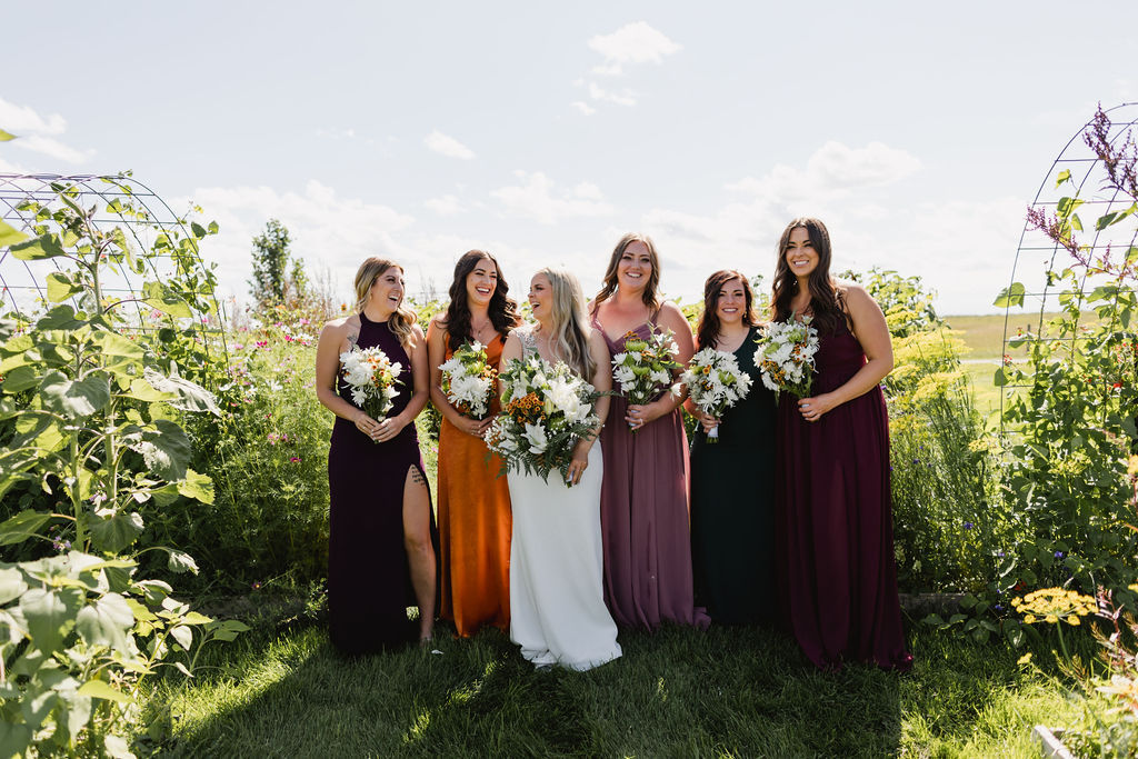 A group of women in dresses holding DIY wedding flower bouquets.