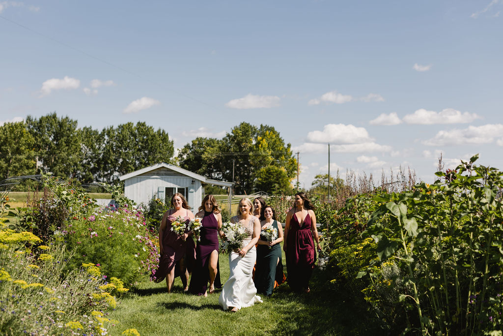 Bridesmaids in mix matched colorful dresses holding DIY wedding floral bouquets