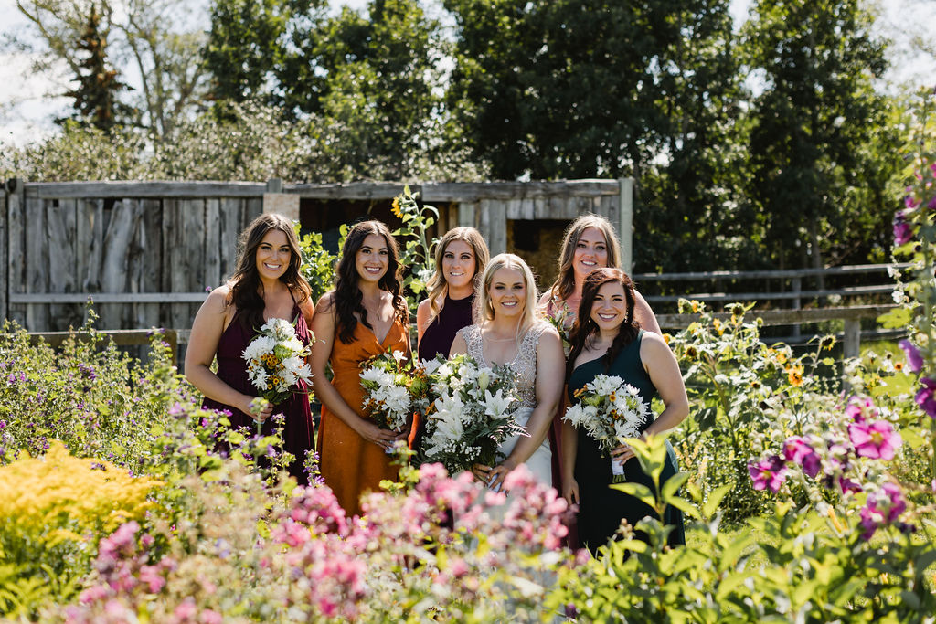 A group of bridesmaids standing in a flower garden.