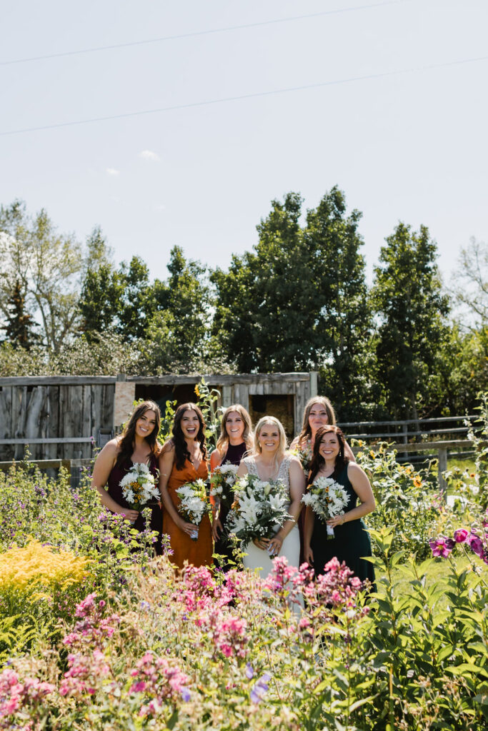 Bridesmaids in mix matched colorful dresses holding DIY wedding floral bouquets
