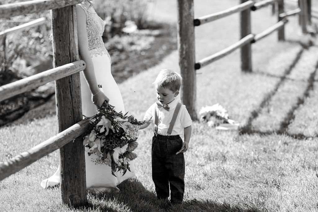 A bride and groom standing next to a fence.