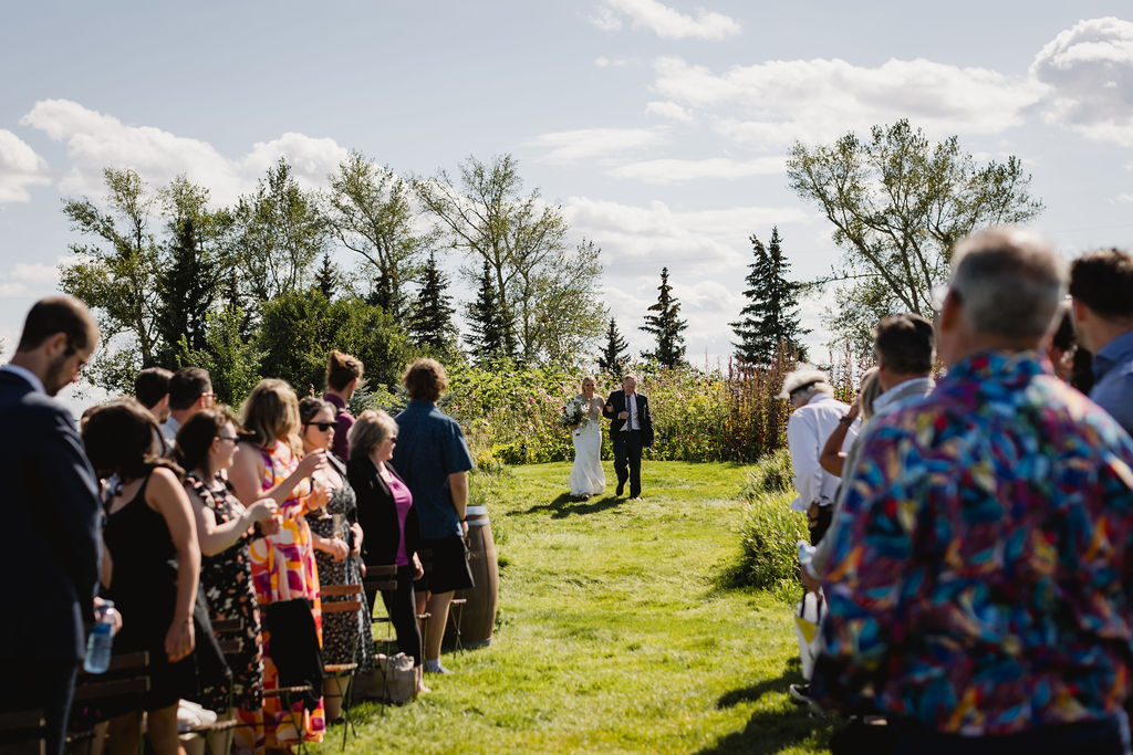 A wedding ceremony in a field with a bride and groom.