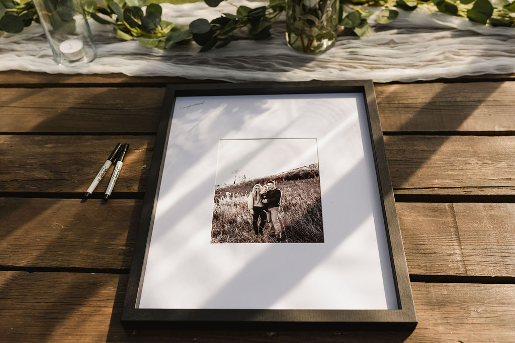 A framed photo of a couple sitting on a table.