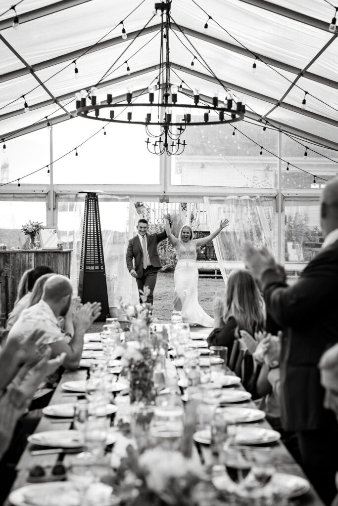 A bride and groom at a wedding reception in a tent.