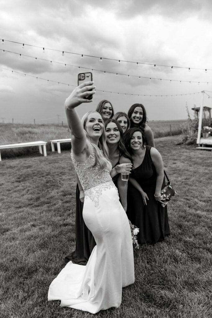 A bride and her bridesmaids taking a selfie.