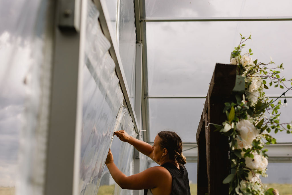 A woman is putting flowers on a glass door.