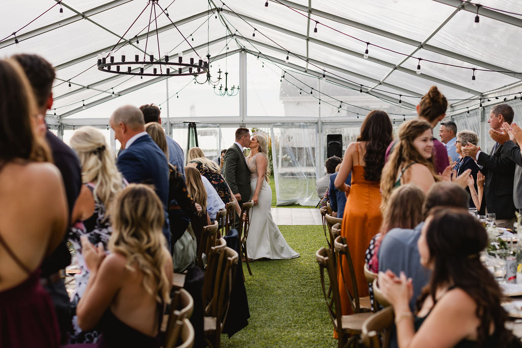A wedding reception in a tent with a bride and groom.