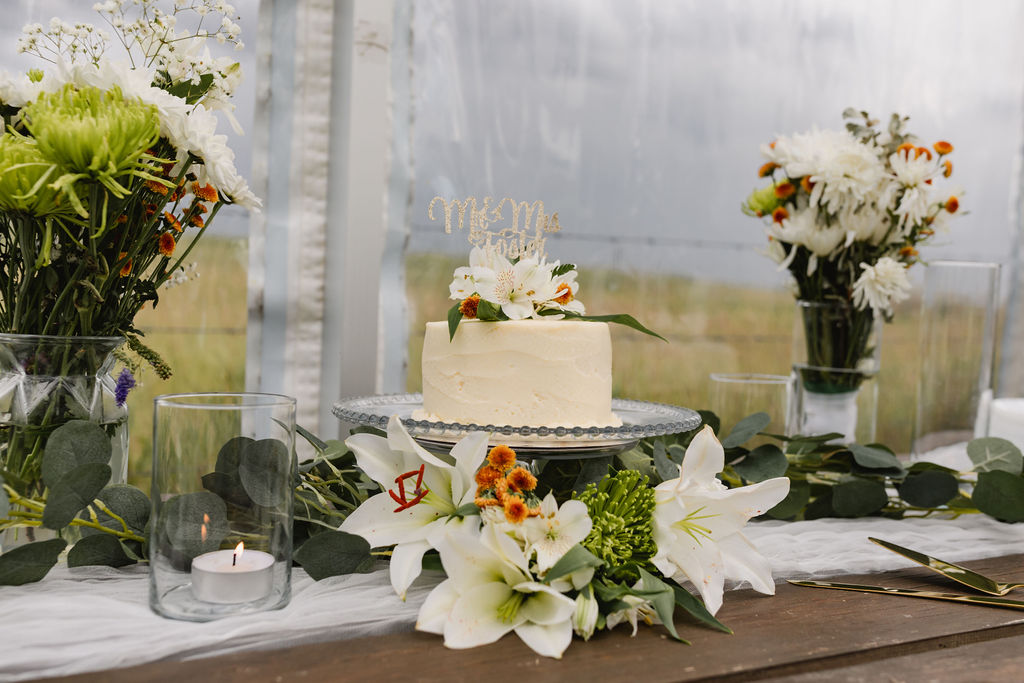 A wedding cake and flowers on a table.