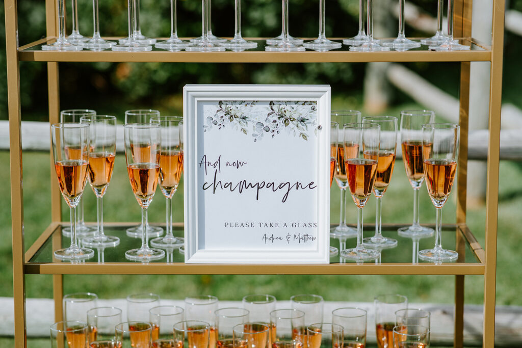 Elegant champagne display with a sign inviting guests to take a glass.