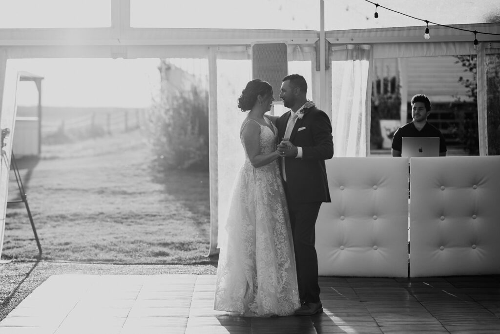 Bride and groom sharing a dance at their wedding reception in a black and white photo.