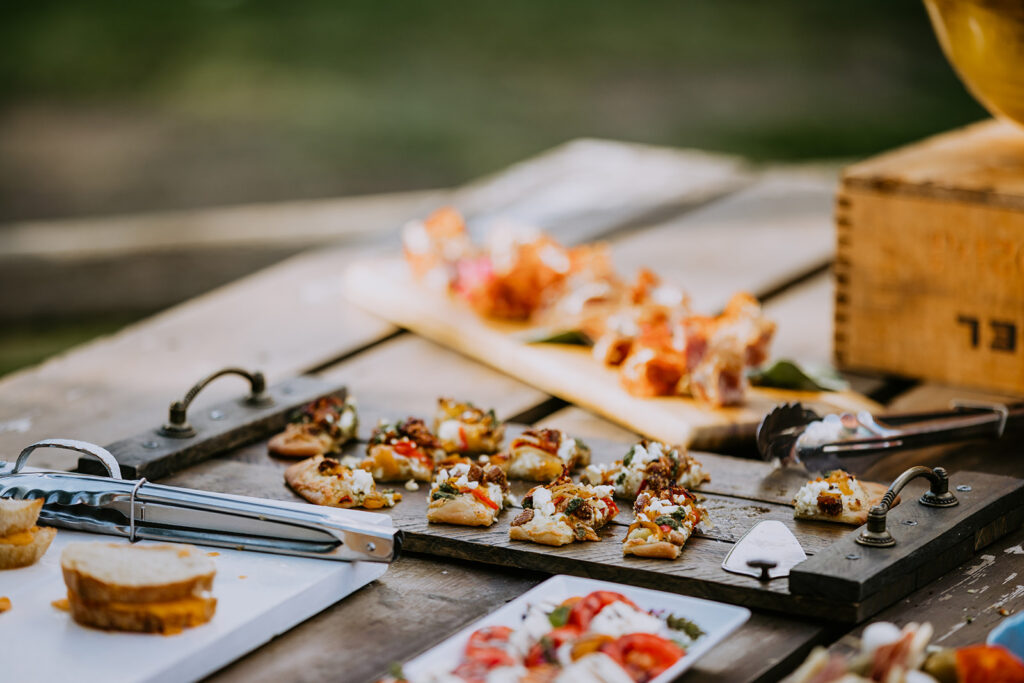 Assorted appetizers on a wooden serving board with a blurred background.