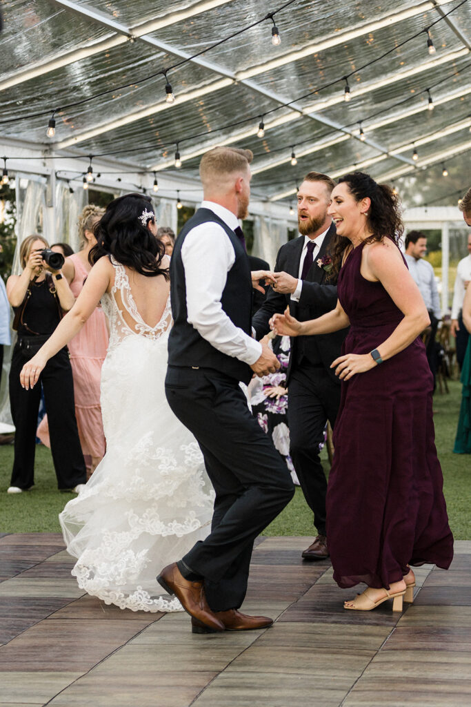 Guests dancing joyfully at a wedding reception.