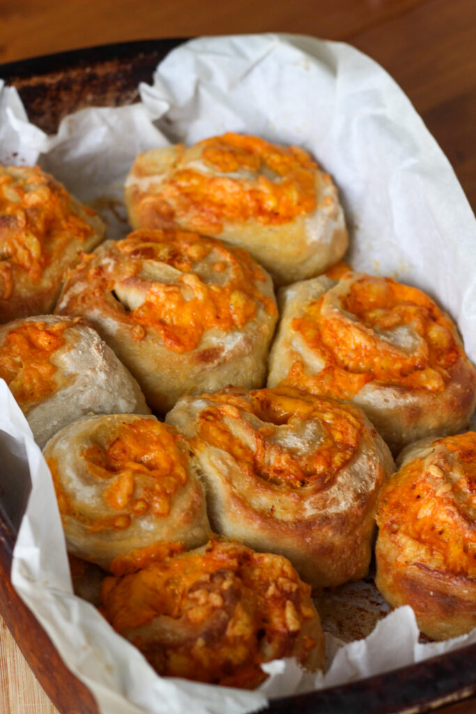 Irresistible Sourdough Cheese Buns. Freshly baked cheese-topped rolls in a baking dish.