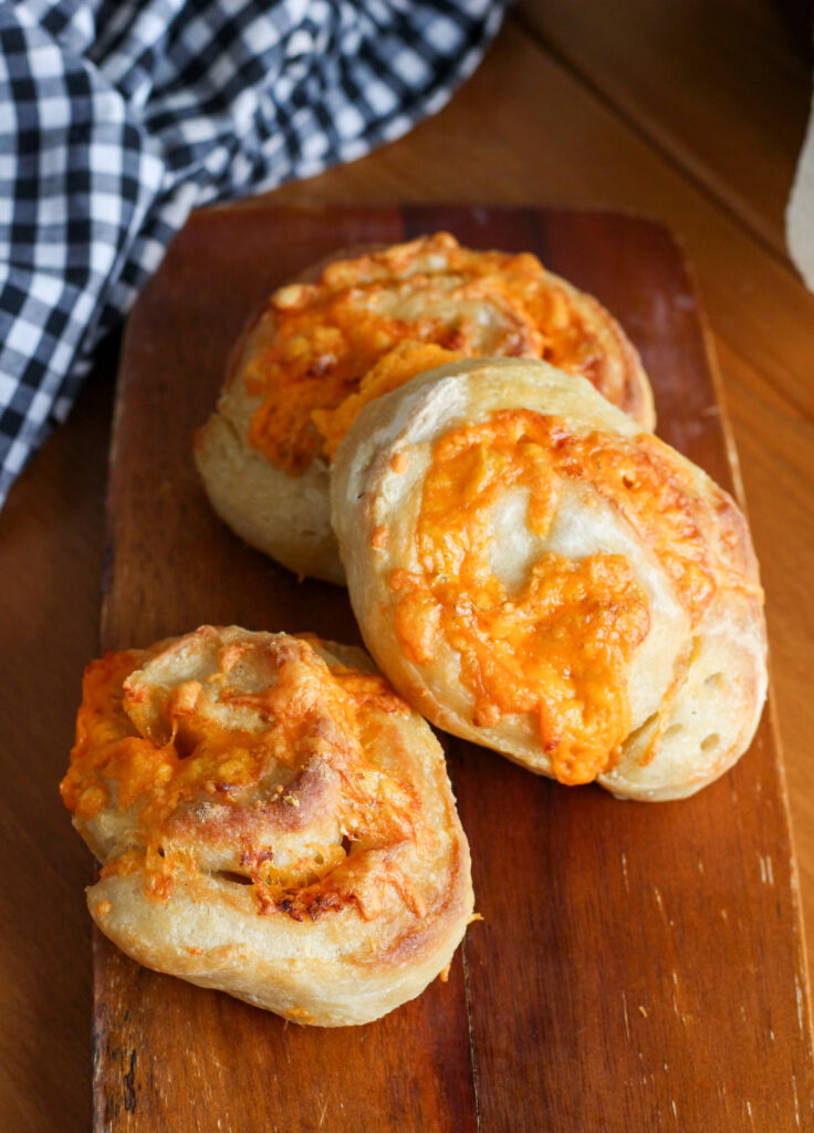 Irresistible Sourdough Cheese Buns  on a wooden serving board. 